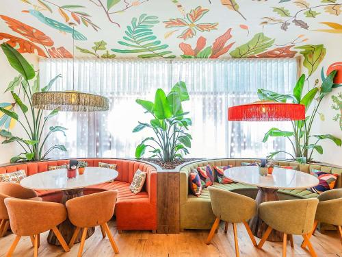 een restaurant met 2 tafels en een bank bij Hotel Ibis Lisboa Parque das Nações in Lissabon