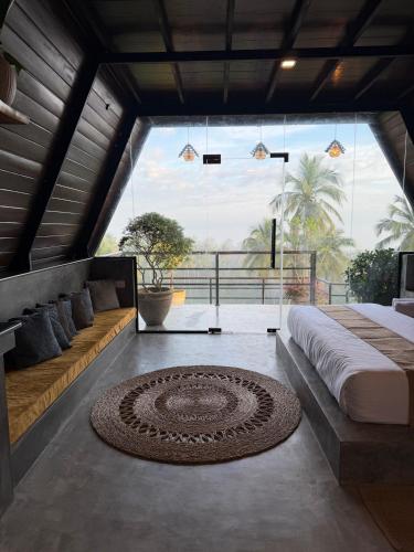 a bedroom with a bed and a large window at Kurunda Estate Villa in Tangalle