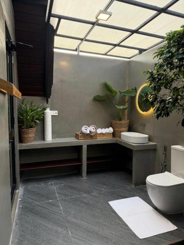 a bathroom with a sink and a toilet and plants at Kurunda Estate Villa in Tangalle