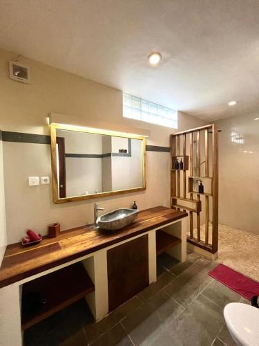 a bathroom with a sink and a large mirror at Mango Selong in Selong Belanak