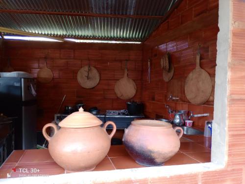 due grandi vasi appoggiati su un bancone in cucina di Ecuturisticos Barbacoa casa de la luna a Cáqueza