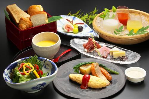 een tafel met borden en een doos brood bij まち宿 壱龍 MACHIYADO ICHIRYU in Takayama