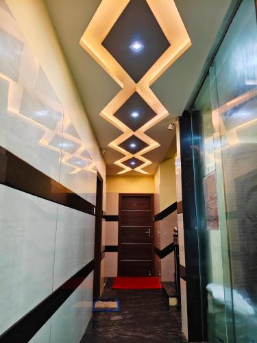 ein Flur mit einer Decke mit Lichtern und einer Tür in der Unterkunft Galaxy Beach Residency in Velankanni