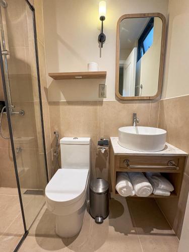 a bathroom with a toilet and a sink and a mirror at TWIN PALMS 'Beach House' - New surf front location in Thulusdhoo