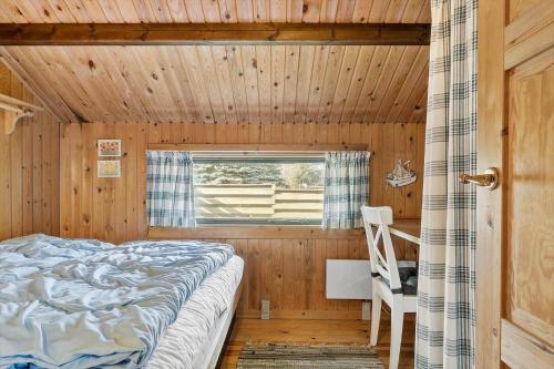 a bedroom with a bed in a wooden room at 0009-Romo-Thadesvej-37 in Høm
