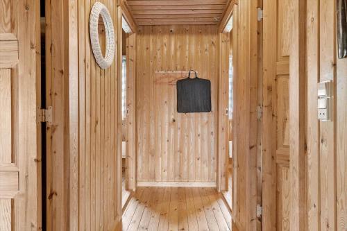 a hallway in a wooden cabin with a tv on the wall at 0009-Romo-Thadesvej-37 in Høm