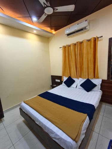 ein Schlafzimmer mit einem großen Bett und blauen Kissen in der Unterkunft Galaxy Beach Residency in Velankanni