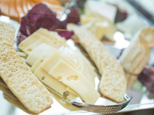 un piatto di formaggio e cracker e una forchetta di Grand Mercure Majlis Residences Abu Dhabi a Abu Dhabi