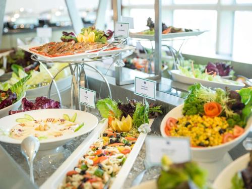 un buffet pieno di diversi tipi di cibo di Grand Mercure Majlis Residences Abu Dhabi a Abu Dhabi