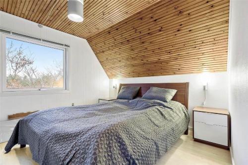 a bedroom with a large bed with a wooden ceiling at 11804-Nykobing-Sj-Linesvej-2 in Nyrup
