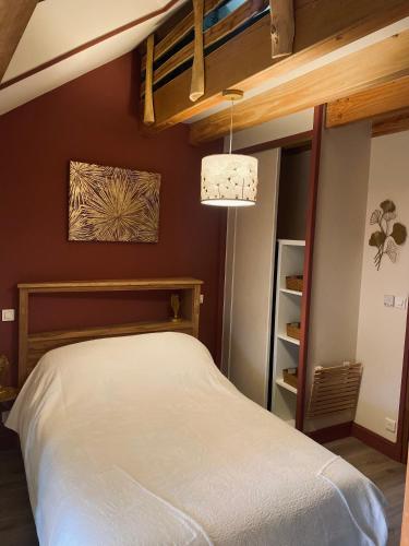 a bedroom with a white bed and a chandelier at La Longère des Oies in Saint-Thibault