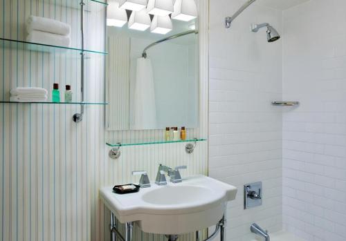 une salle de bain blanche avec lavabo et douche dans l'établissement Hotel Baltimore Downtown-Inner Harbor, à Baltimore