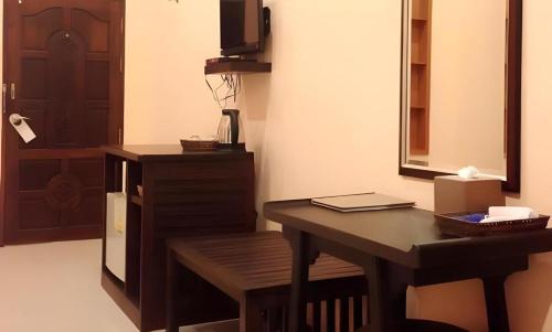 een kamer met een bureau, een tafel en een spiegel bij Pharadhevi in Ban Dung