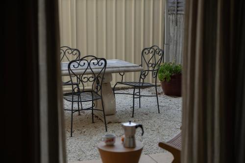 a patio with a table and chairs and a plant at La Costa Shoal Bay in Shoal Bay