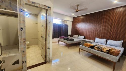 a living room with two beds and a shower at BRAHMANCHAL guest house in Barsāna