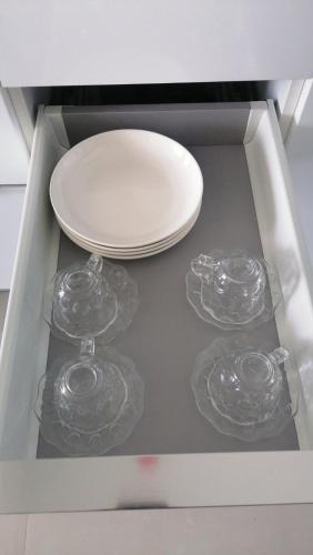 een wit bord en drie wijnglazen in een lade bij Daily Relax Inn -Apartment Rooms- Hulhumale' in Furanafushi