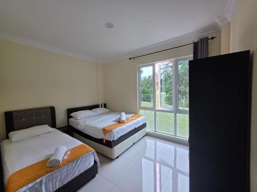 a bedroom with two beds and a large window at Teeview Homes 9A in Tanah Rata
