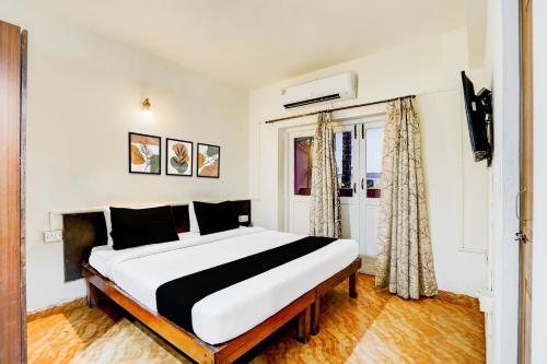 a bedroom with a large bed in a room at Super Collection O Holiday Street Calangute Formerly Shruti Resort in Goa