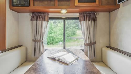 a book sitting on a table in front of a window at Goseong Jjun Camping Pension in Goseong