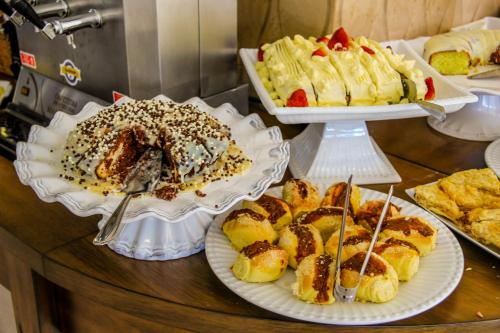 a table topped with plates of pastries and desserts at Hotel Gramado Interlaken in Gramado
