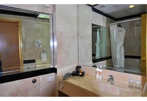 een badkamer met een wastafel en een grote spiegel bij Happy Days Hotel in Manamah