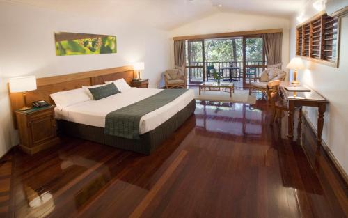 a hotel room with a bed and a balcony at Thala Beach Nature Reserve in Oak Beach