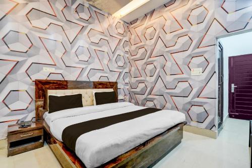 a bedroom with a bed and a wall with a geometric pattern at Collection O Rudrapur Bus Stand Formerly Corinthian in Rāmpura