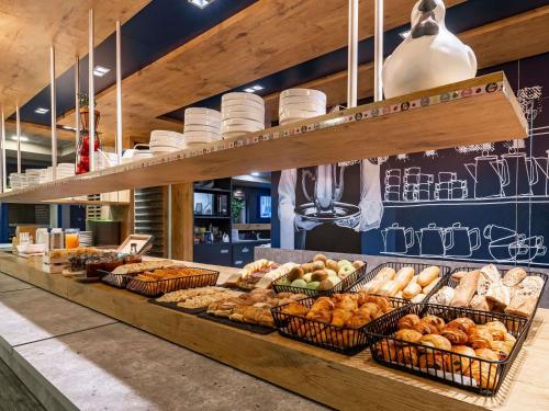 un comptoir de boulangerie avec des paniers de pain et de viennoiseries dans l'établissement ibis budget Marne la Vallée Pontault Combault, à Pontault-Combault