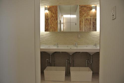 a bathroom with a sink and a mirror at Backpackers Hotel NOOSA JAPAN in Takatsuki Tonda in Takatsuki