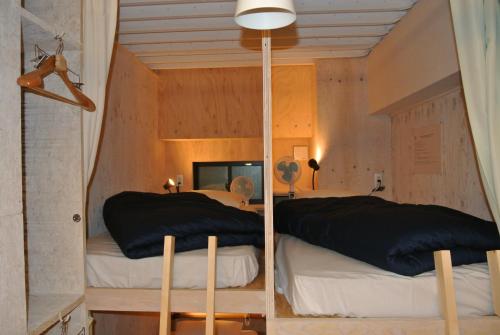 a bedroom with two beds and a mirror at Backpackers Hotel NOOSA JAPAN in Takatsuki Tonda in Takatuki