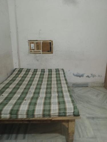 a green and white bed in a room at josh poonam in Prayagraj