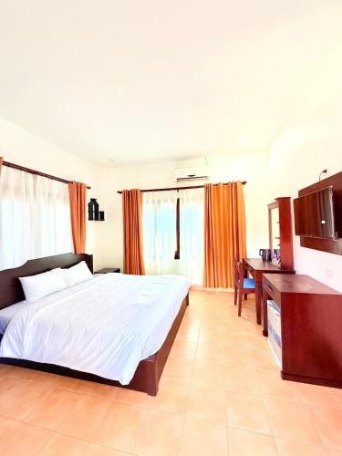 a bedroom with a large bed and a desk at Vang Vieng Ruby Villa Hotel in Vang Vieng