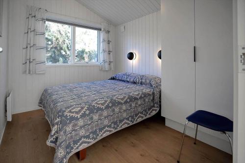 een kleine slaapkamer met een bed en een raam bij 10070-Rorvig-Kirkestien-25 in Rørvig