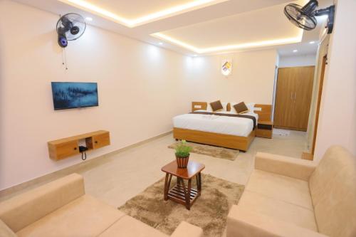 a bedroom with a bed and a living room at Munderi Green Mounts - Family Rooms with Pool, Wayanad, Kalpetta in Kalpetta