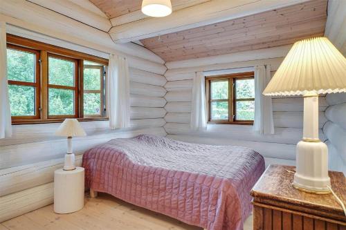 een slaapkamer met een bed in een kamer met ramen bij 12254-Nykobing-Sj-Peter-Andersensvej-5 in Tjørneholm