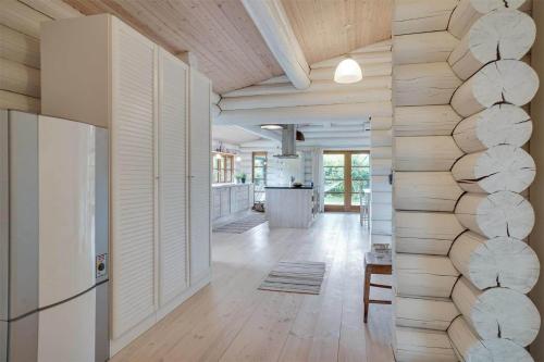 een keuken en woonkamer met een muur van boomstammen bij 12254-Nykobing-Sj-Peter-Andersensvej-5 in Tjørneholm