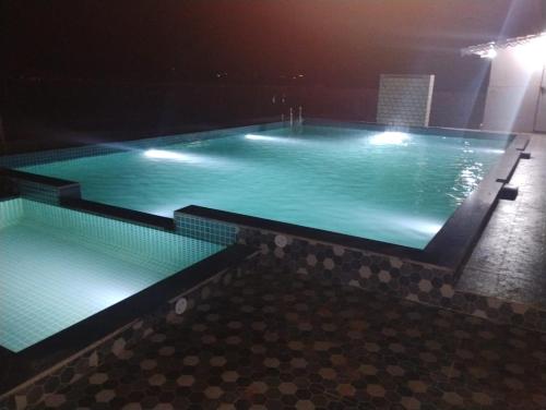 ein großer Pool mit blauem Wasser in der Nacht in der Unterkunft Royal Casa Resort Diveagar in Borlai Panchaitan