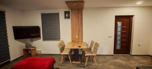 een eetkamer met een tafel, stoelen en een tv bij Suncani Breg in Crni Vrh