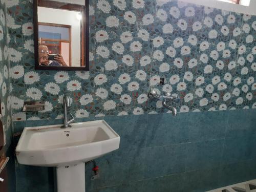 a person taking a picture of a sink in a bathroom at Hotel Arpit in Sonprayag