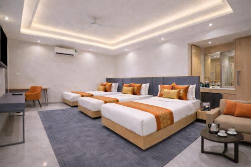 a large hotel room with two beds and a couch at Hotel Apple Wood Delhi Airport With Free Airport Drop in New Delhi