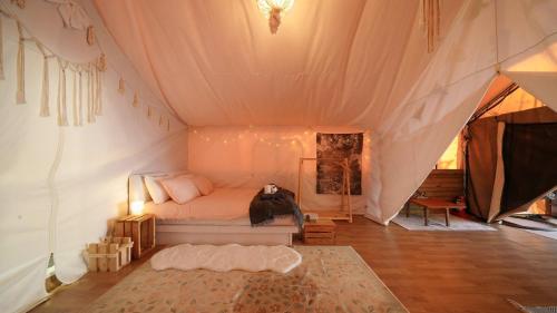 een slaapkamer met een bed in een tent bij Gapyeong ILUGlamping in Gapyeong
