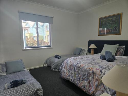 ein Schlafzimmer mit zwei Betten und einem Fenster in der Unterkunft Waterfront Hideaway with Pool, Spa & BBQ Area jetty available in Mandurah