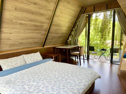 a bedroom with a bed and a desk and a window at Vạn Tùng Homestay & Café in Xuan An