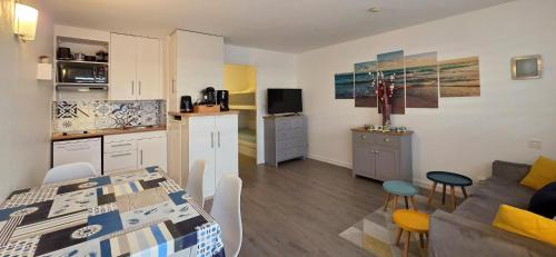 eine Küche und ein Wohnzimmer mit einem Tisch und einer Couch in der Unterkunft ESCAPADE FAMILIALE A LA MER in Quiberon