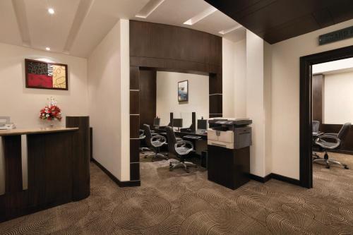 an office with a desk and chairs in a room at Ramada Plaza by Wyndham JHV Varanasi in Varanasi