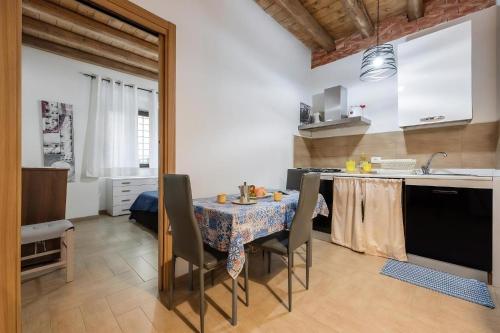 a kitchen with a table with chairs and a sink at Damiani Appartamenti nel Centro Storico di Palermo in Palermo