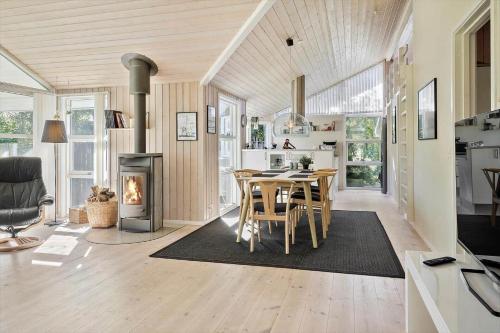 a kitchen and dining room with a table and a fireplace at LF10210-Thyholm-Skovstien-10 in Thyholm