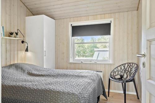 a bedroom with a bed and a window at LF10210-Thyholm-Skovstien-10 in Thyholm