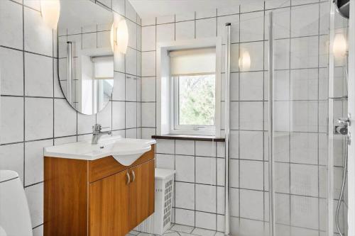a bathroom with a sink and a mirror and a shower at LF10229-Thyholm-Skovstjernevej-9 in Thyholm