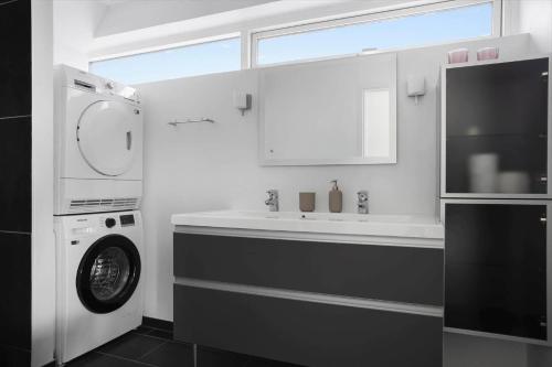 a bathroom with a sink and a washing machine at LF10214-Thyholm-Havnefronten-14 in Thyholm